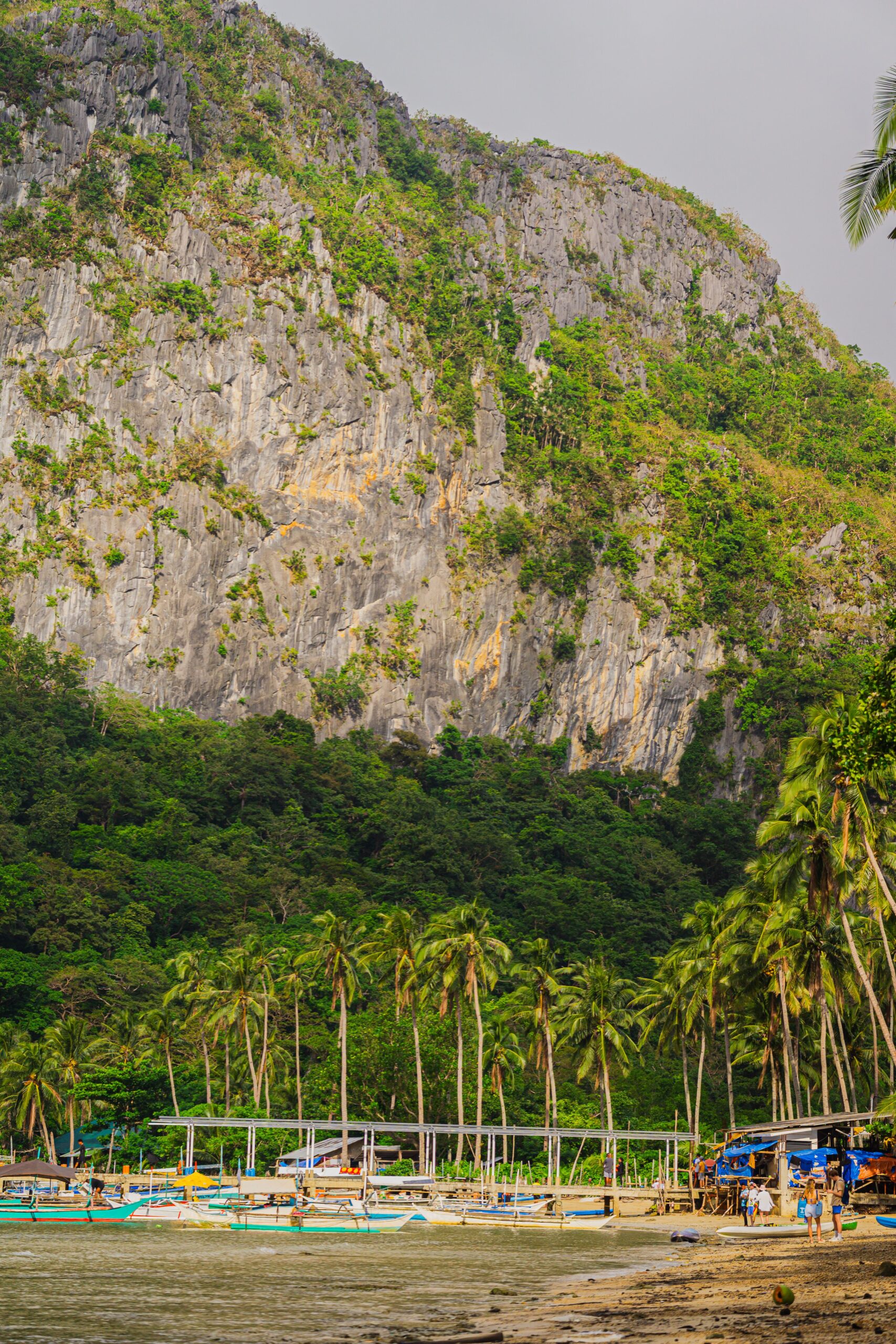 Beach and limestone cliffs beside island waters in Philippines